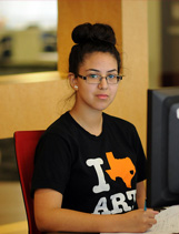 Seated student wearing t-shirt that reads: I love art. (The word "love" has been replaced with a Texas icon.)