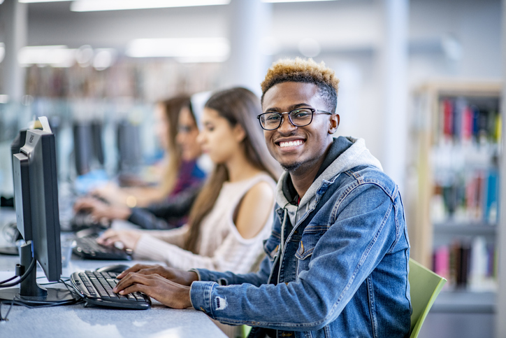 student on computer smiling