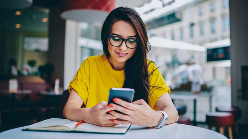 Woman with glasses looking at her phone