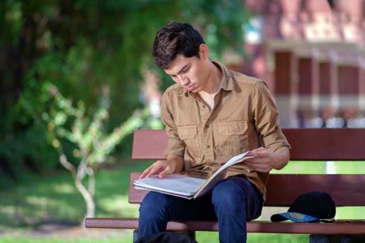 student reading on a bench
