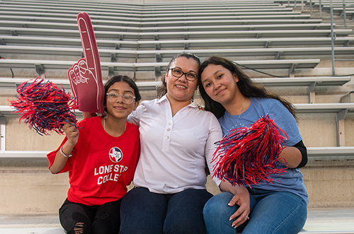 a mom and two daughters in lone star college apparel