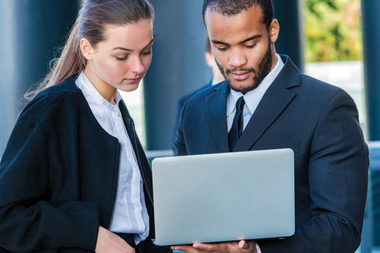 Photo of 2 people working at a laptop