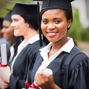 Portrait of a student in a cap and gown carrying a diploma