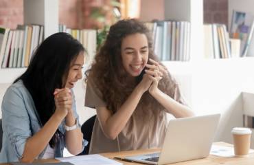 Two girls laughing looking at computer