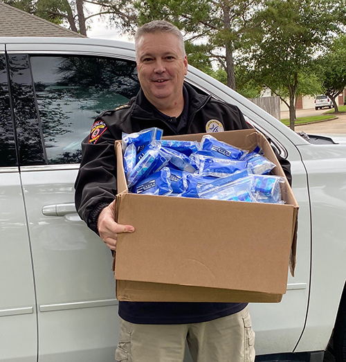 Policeman holding box of sanitizer and gloves