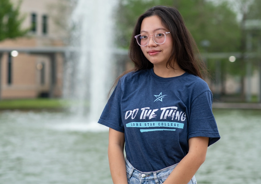 College student standing in front of a fountain