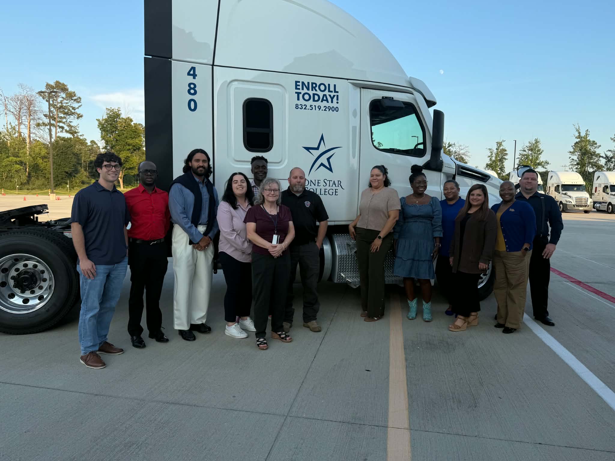 Alumni Council standing in front of a big rig truck