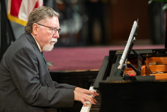 Photo of Music Director Dr. Robert Hunt playing piano