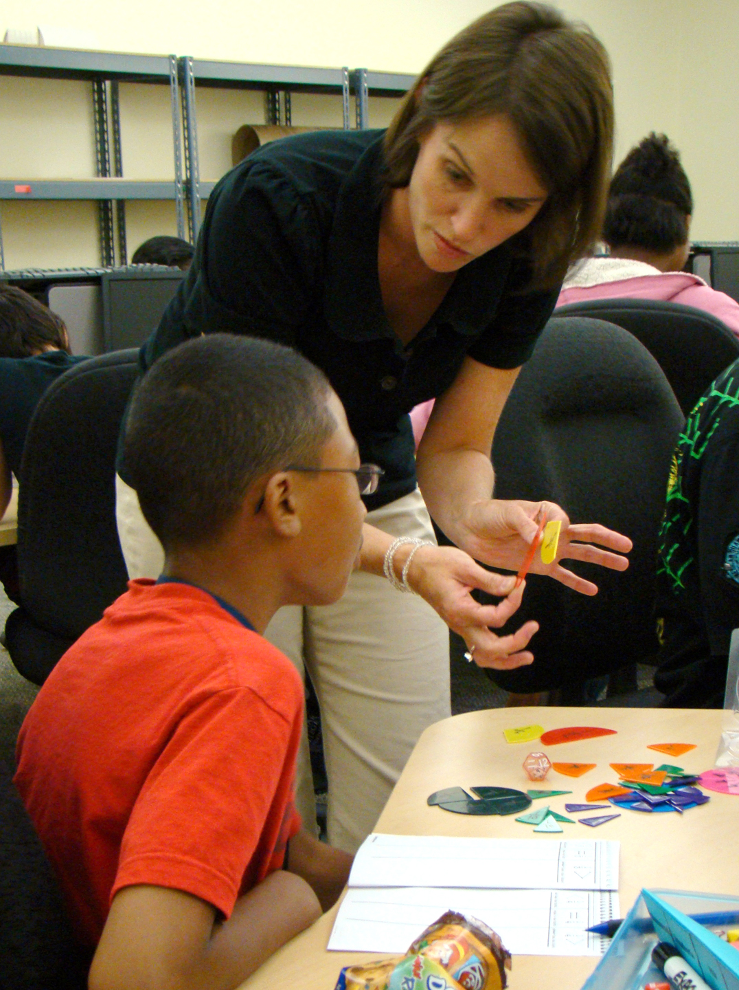 Lauren Stallings, a volunteer math instructor at Lone Star College-Montgomerys FUN Summer Program, reviews fractions with Theory Bowen, a sixth-grade student from Travis Intermediate in CISD.