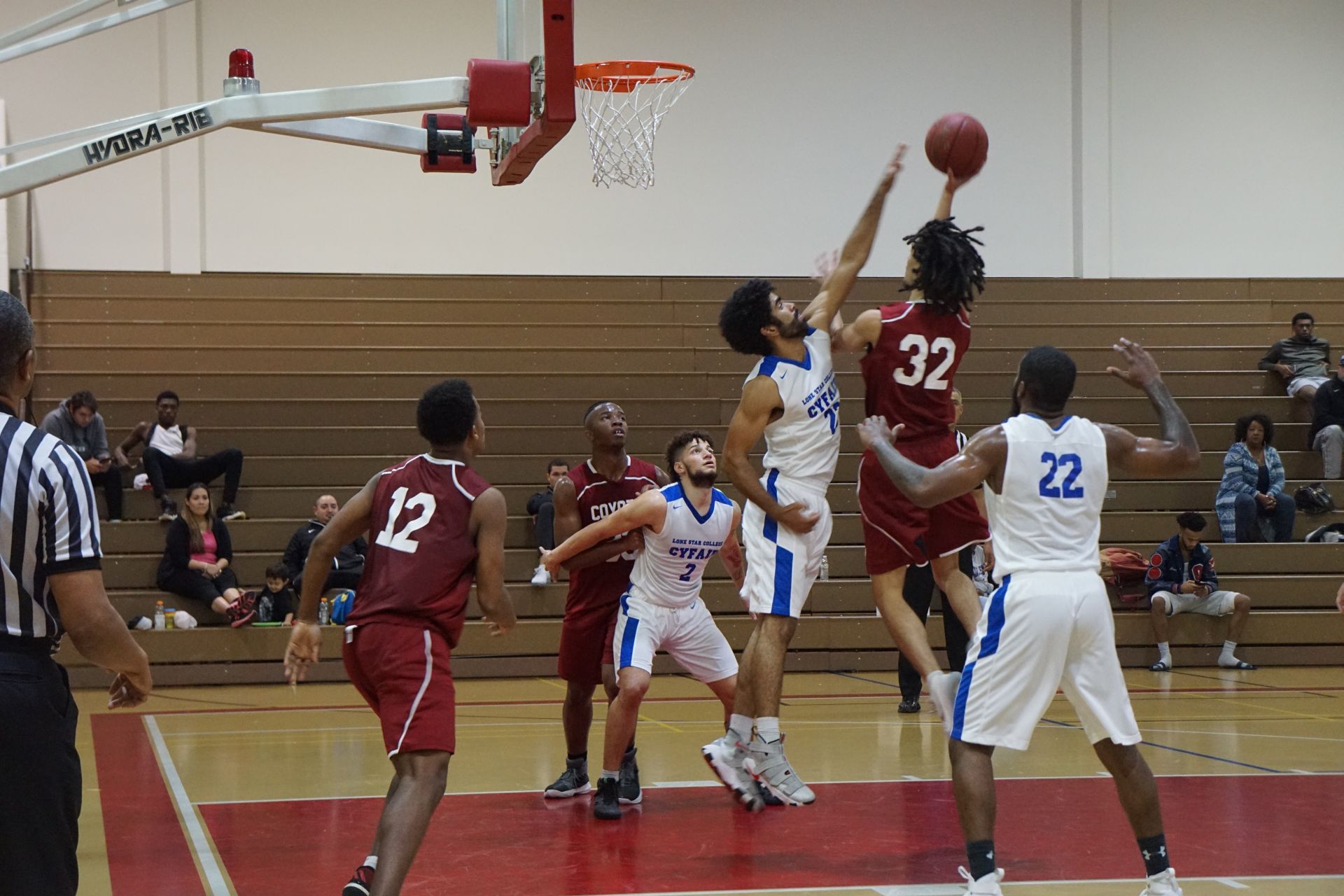 Photo of students from two different teams playing basketball