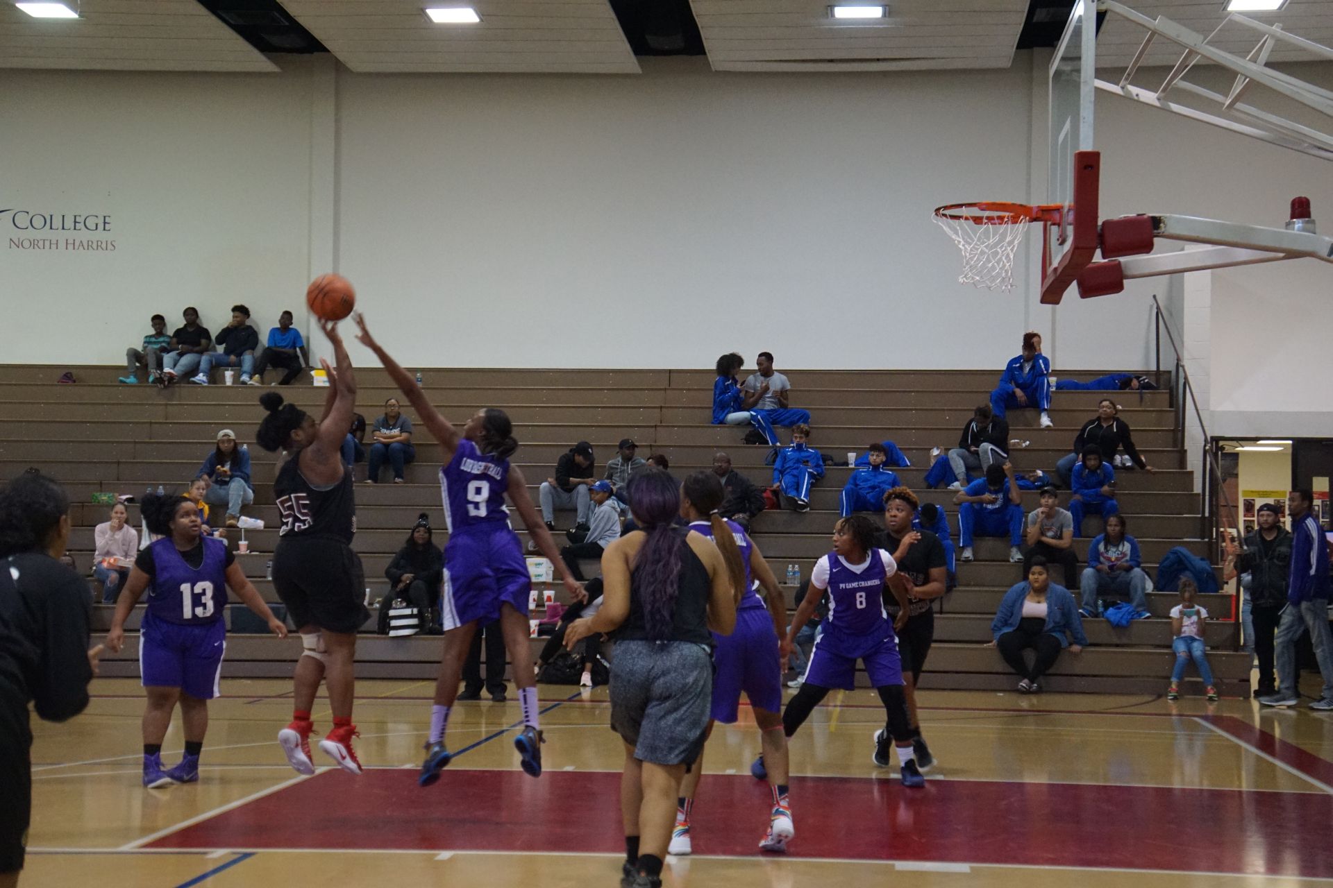 Photo of students from two different teams playing basketball