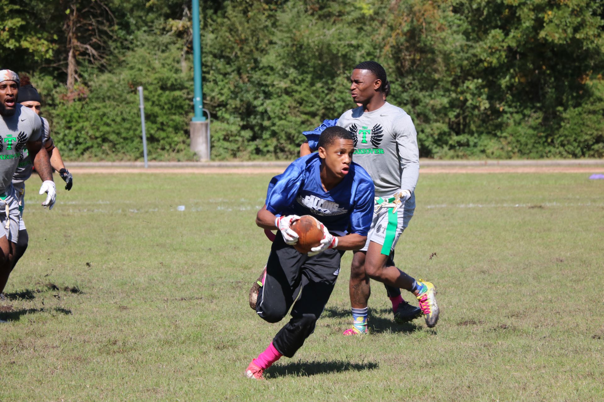 Photo of students from two different teams playing flag football