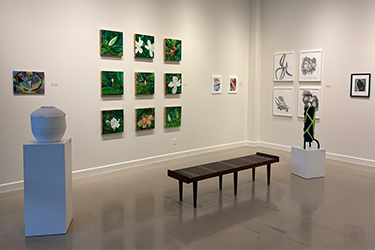 shot of Fine arts gallery with ceramic hot, wooden bench, and various bright green colored paintings