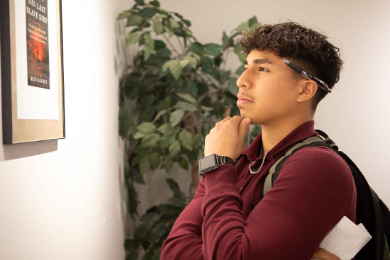 LSC-Tomball student, Jorge Sanchez, considers a work on display at the Juneteenth Black History Month opening at the LSC-Tomball Art Gallery. 