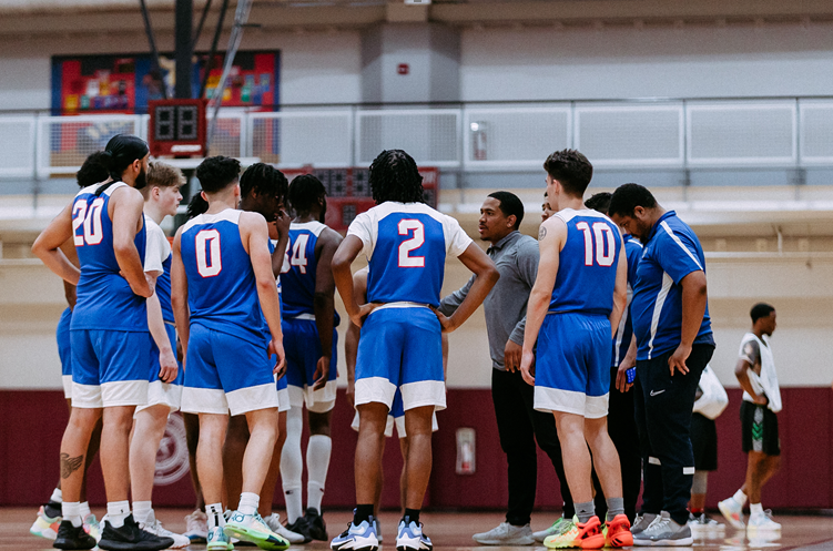 Photo of the LSC-CyFair Men's Basketball team during a time out conversing with their coach