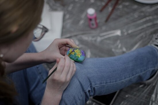 Photo of LSC-Kingwood student painting a stone for Holocaust Remembrance Garden