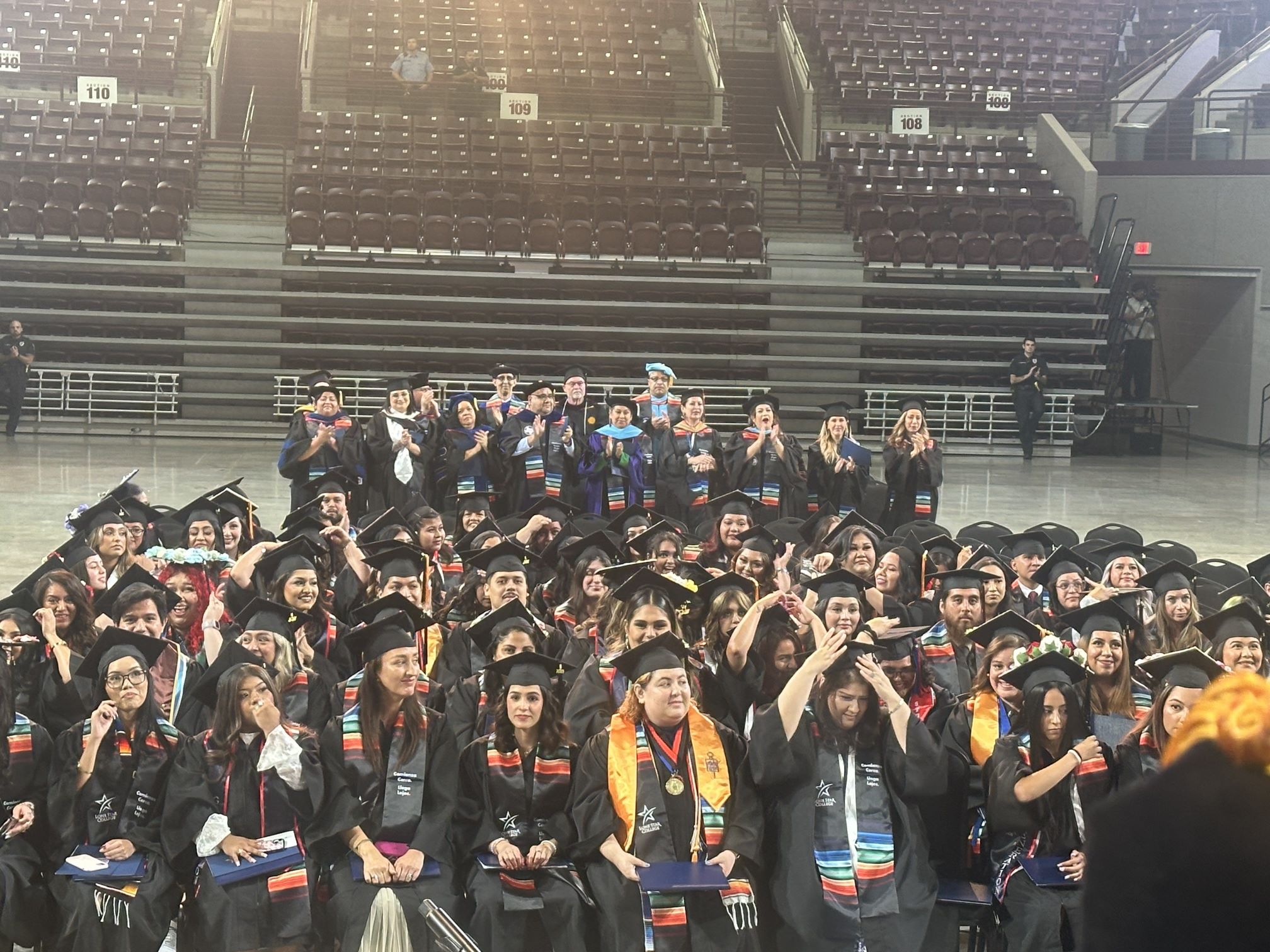 group of happy Hispanic students graduating 