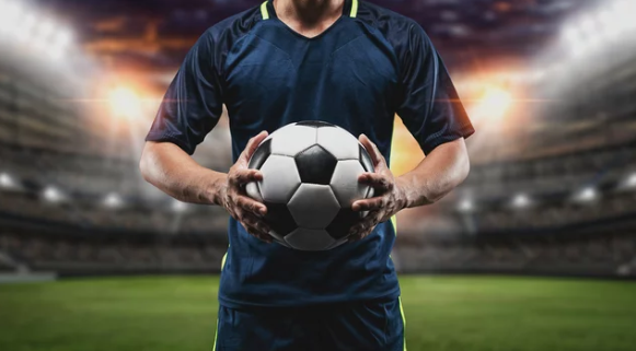 male soccer player holding ball