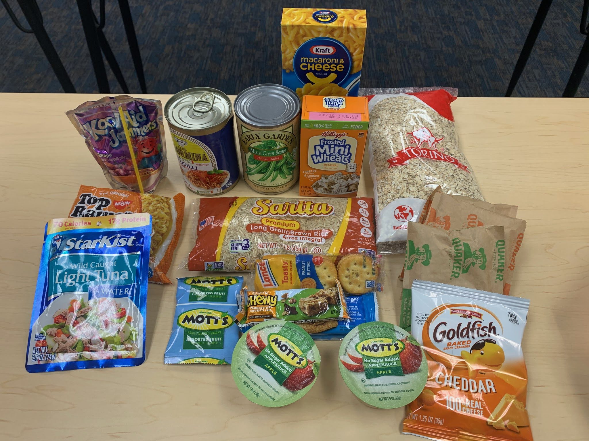 The contents of a small pre-packed grocery bag, as explained in the chart below, laid out on a table.