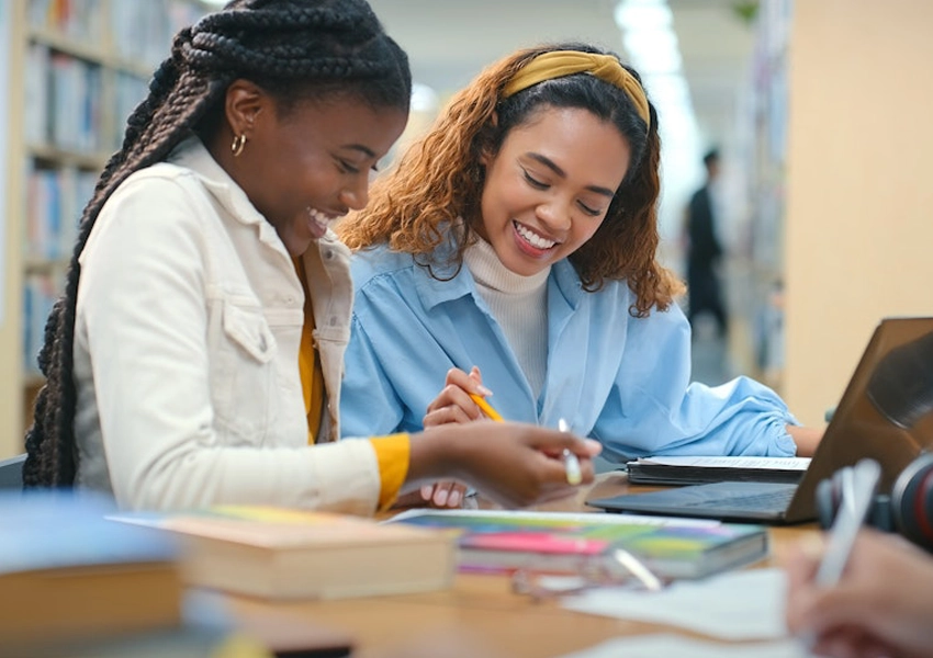 Two smiling students with backpacks