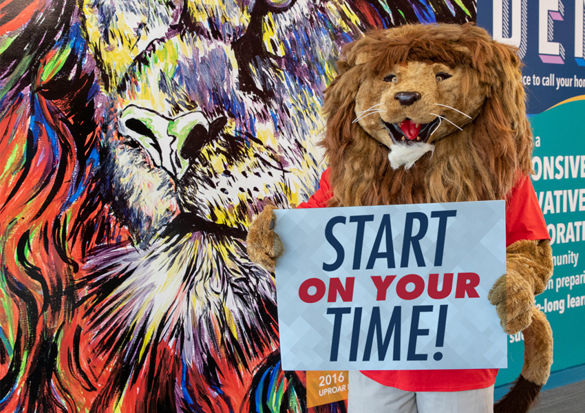 UP Mascot (Leo) Holding Sign that Says 'Start on Your Time'