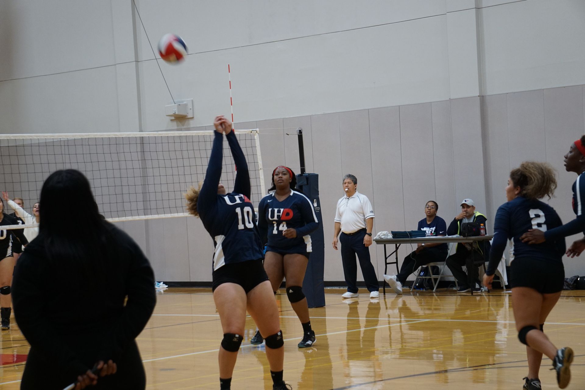 Photo of students from two different teams playing volleyball