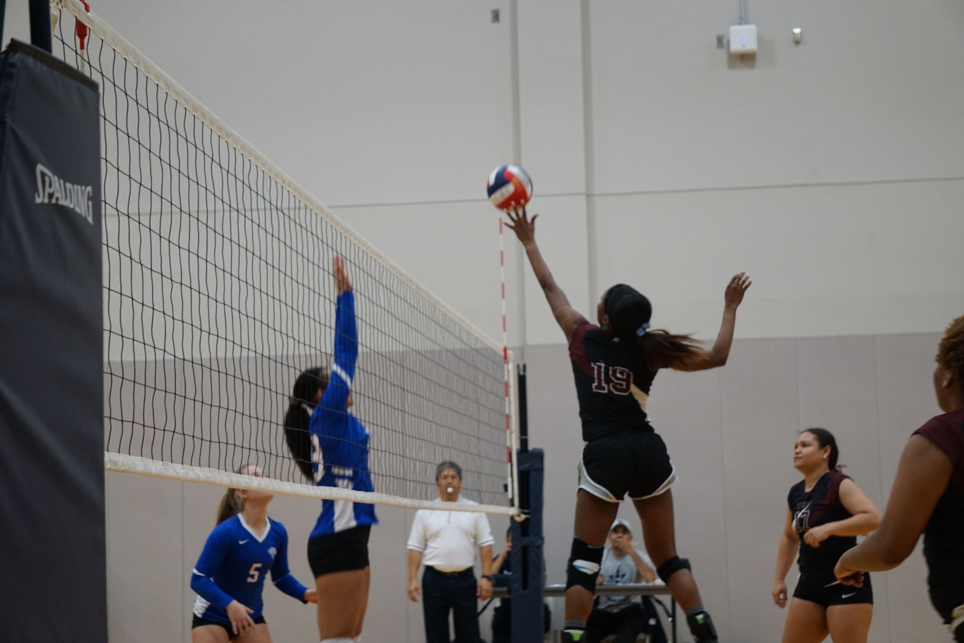 Photo of students from two different teams playing volleyball