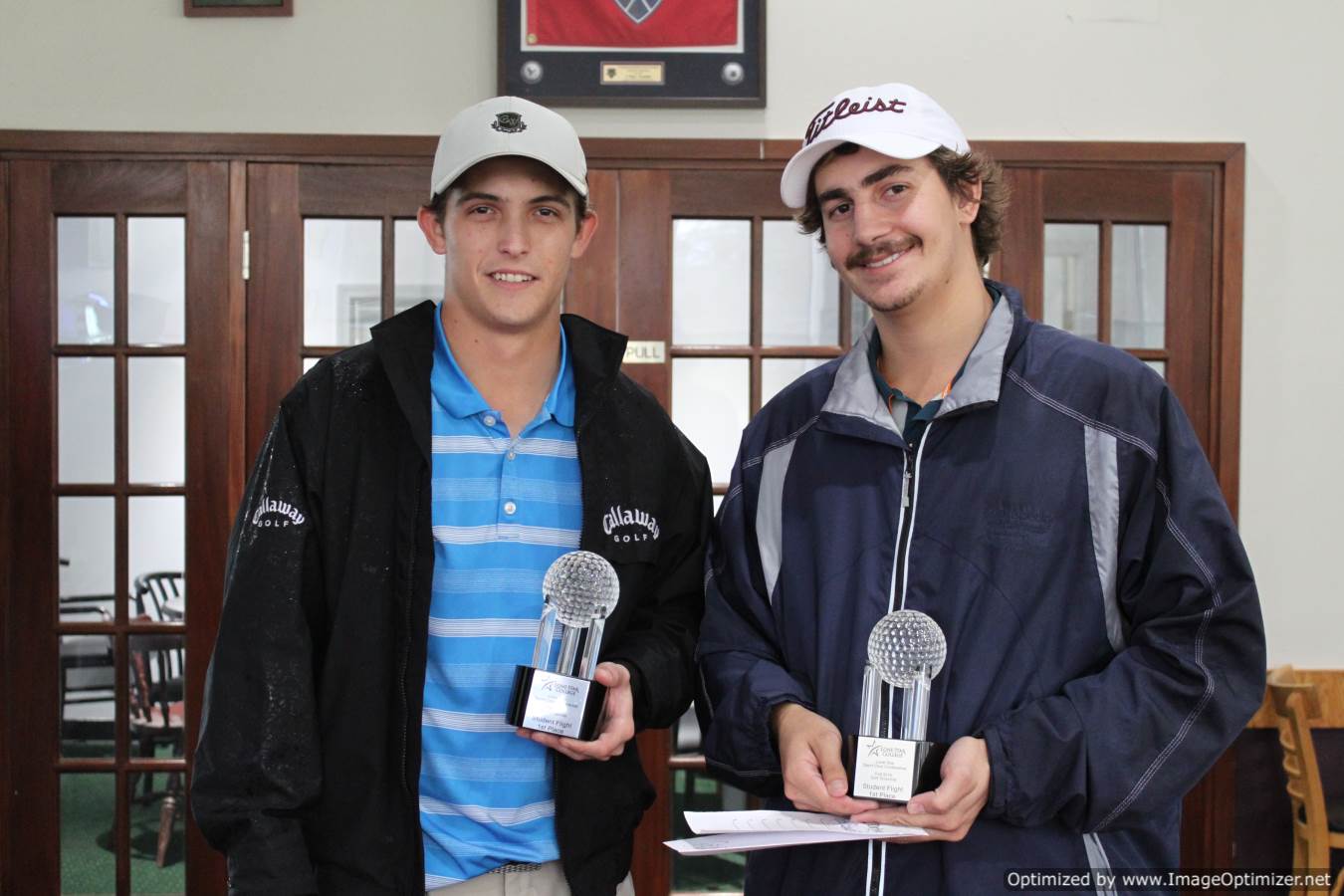 Photo of students posing for photo with a trophy