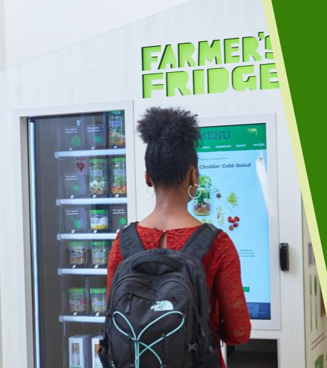 Image of a student looking at the "Farmer's Fridge" vending machine