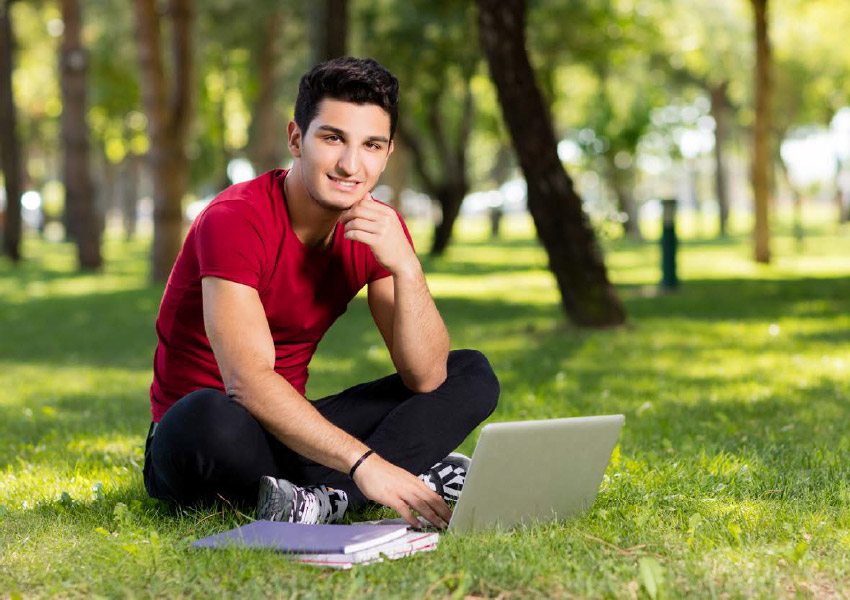 Student outside on his computer