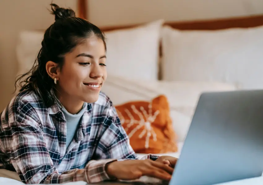 Girl smiling at a laptop