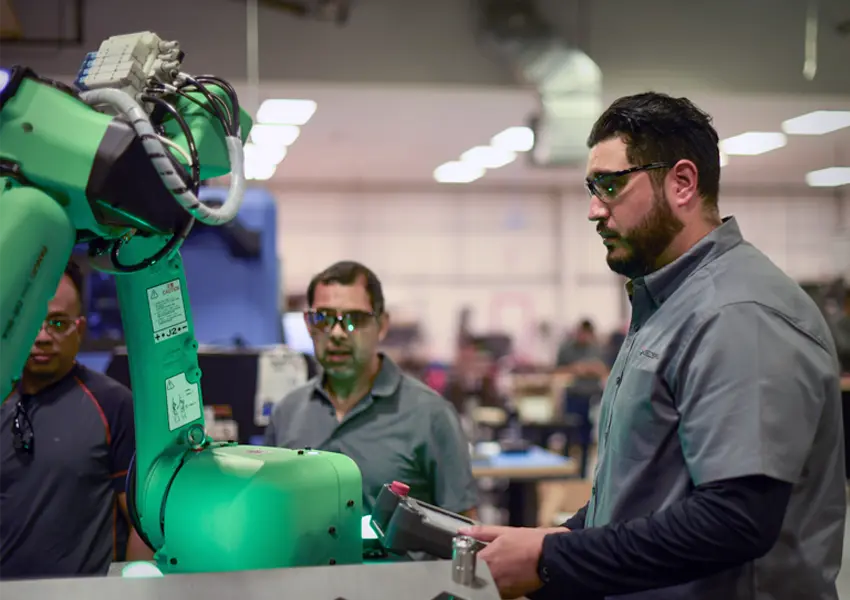 Group of students working with a robotic arm