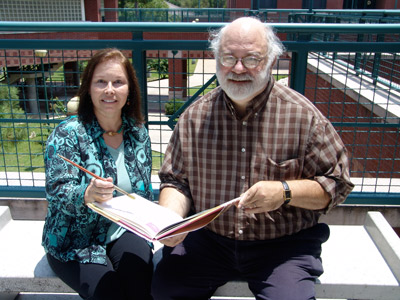 Denis Lorenz, professor of art, playfully prepares to draw in a classic piece of literature held by Ron Heckelman, professor of English, at Lone Star College-Montgomery. The two will merge art and literature in a unique two-class learning community (Art Appreciation and World Literature) that is being offered during the upcoming fall semester at the college.