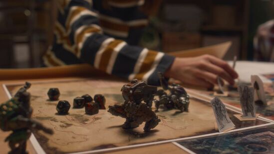 Midsection Shot Of Anonymous Child Looking At Multi Sided Dice And Cardboard Characters Of Tabletop Game At Home
