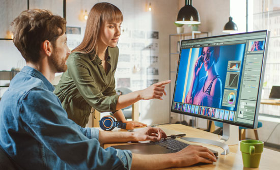 A man and woman using video production software