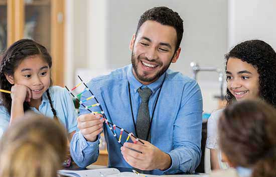 Male elementary school science teacher with his students