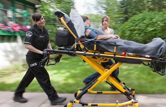 EMS woman pushing an injured person in a stretcher