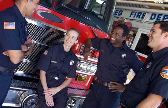 4 fire department memebers standing in front of their fire truck