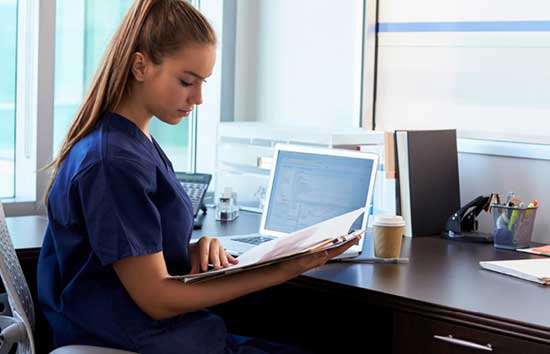 A nurse looks at her clipboard