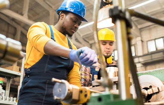 Two men working with a machining tool