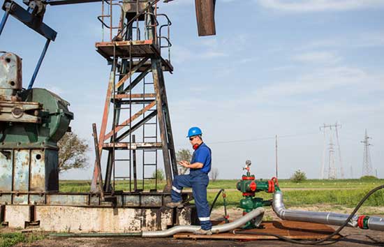 A man standing next to an oil rig stystem