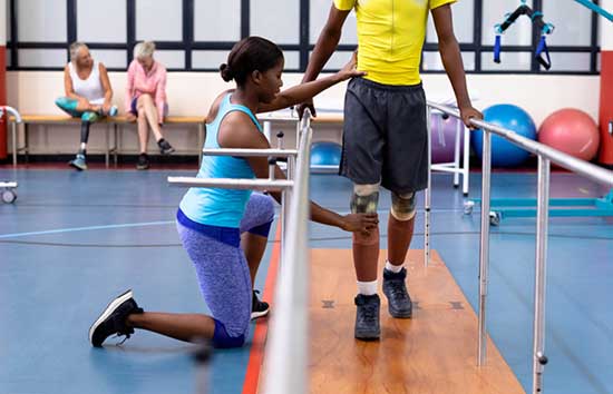 A physical therapist helping a man walk