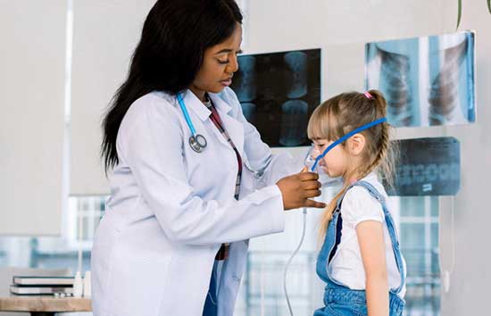 Doctor attaching a breathing device to a girl