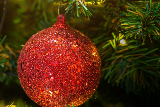 Holiday ornament in a tree, symbolizing the "Sounds of Wonder" chorale performance