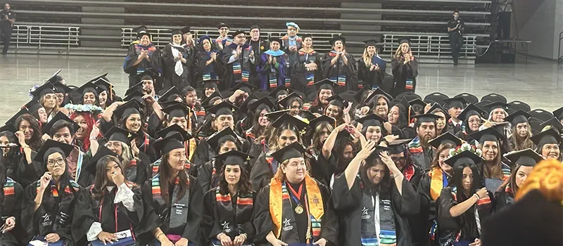 group of happy Hispanic students graduating 