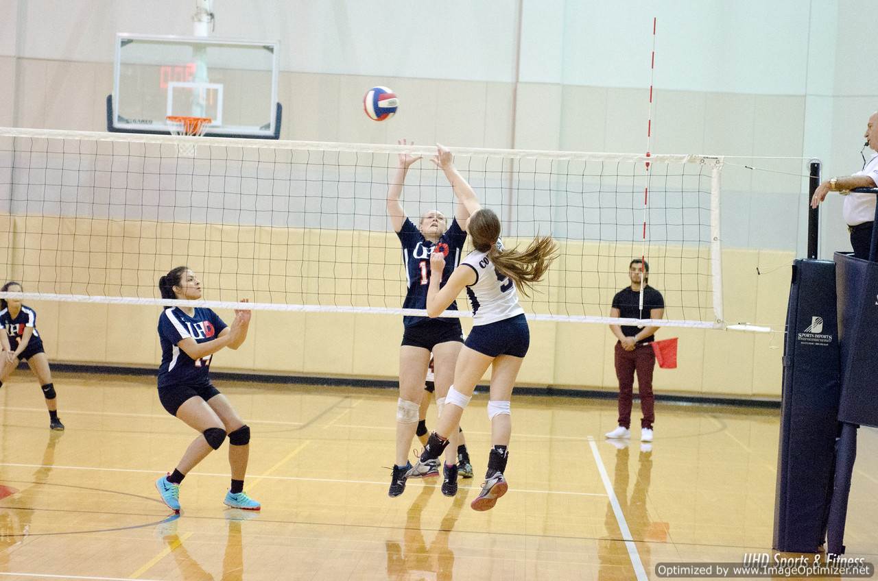 Photo of students from two different teams playing volleyball