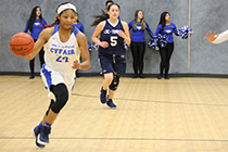 Photo of a LSC-CyFair Women's Basketball player dribbling the ball up the court