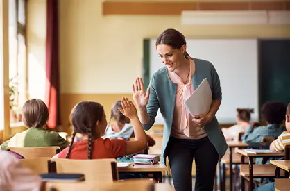 A teacher high fives a student