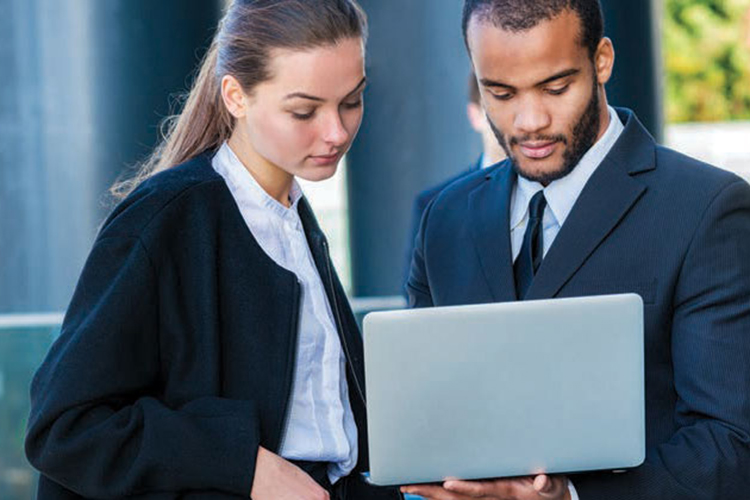 female and male business administrators looking at a laptop