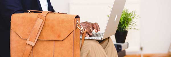 Briefcase and a man on his laptop